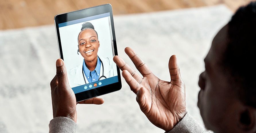 Man video conferencing with a doctor using a tablet during a teleaudiology appointment