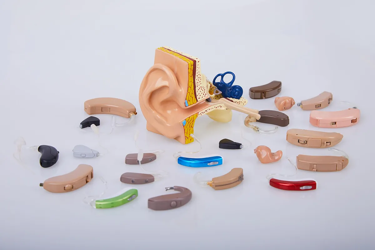 Photo of a variety of different hearing aids laid out on table