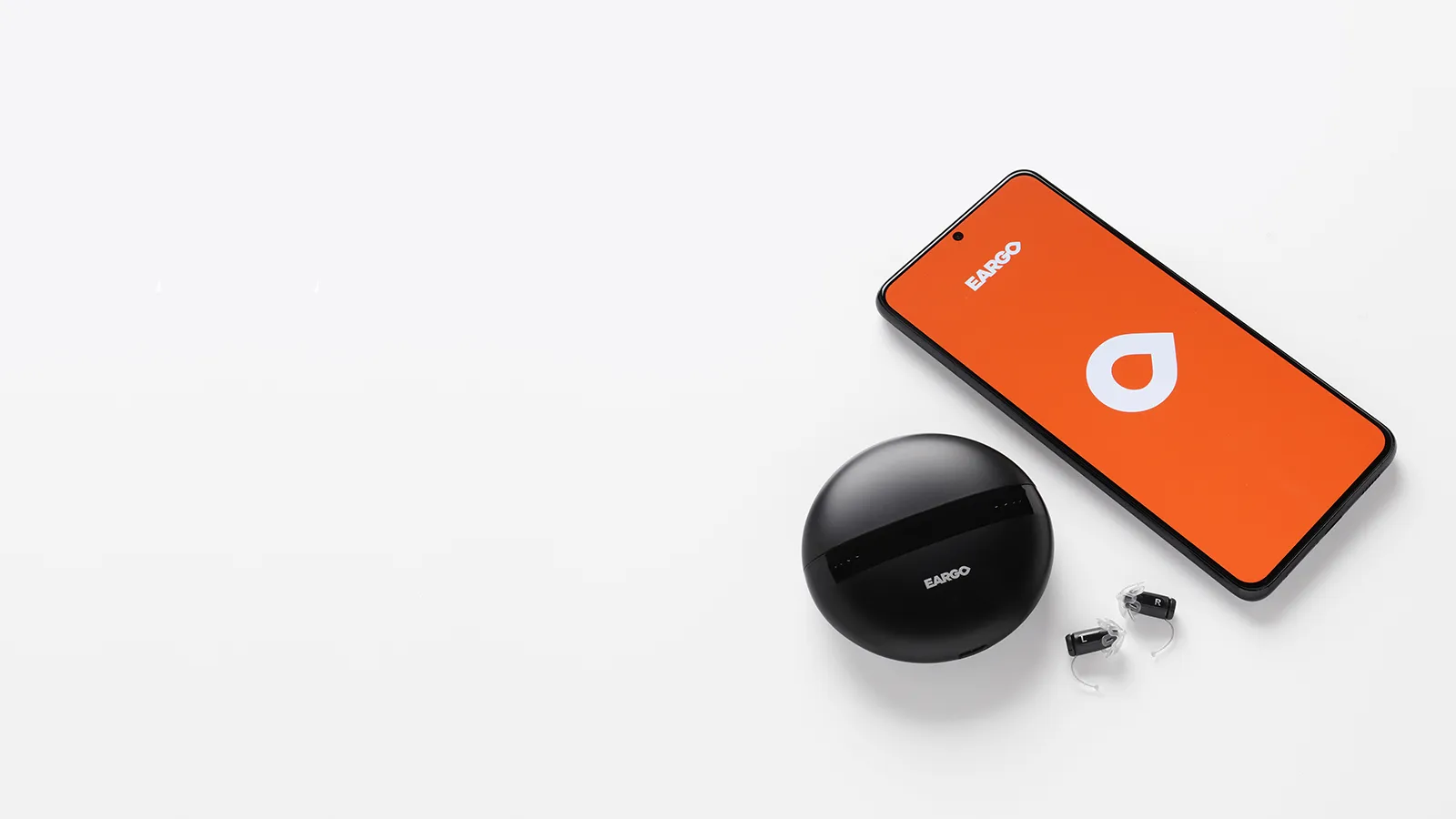 Eargo hearing aids with charger and mobile app on phone screen