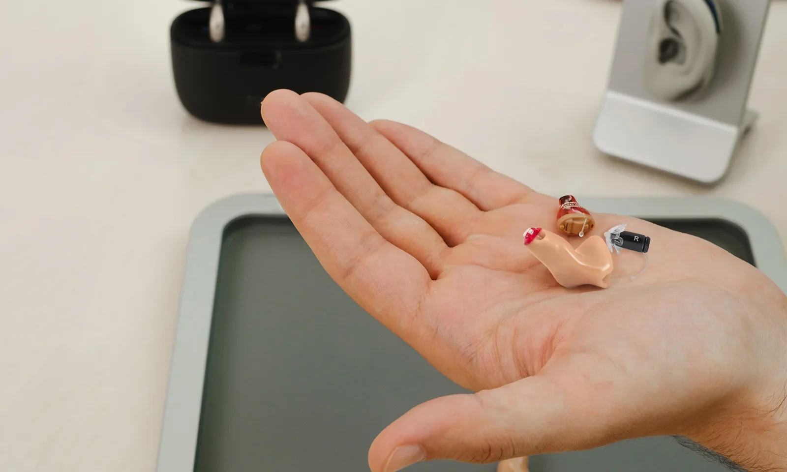 various hearing-aid styles in palm of hand, showing how small Eargo hearing aids are when compared to other styles
