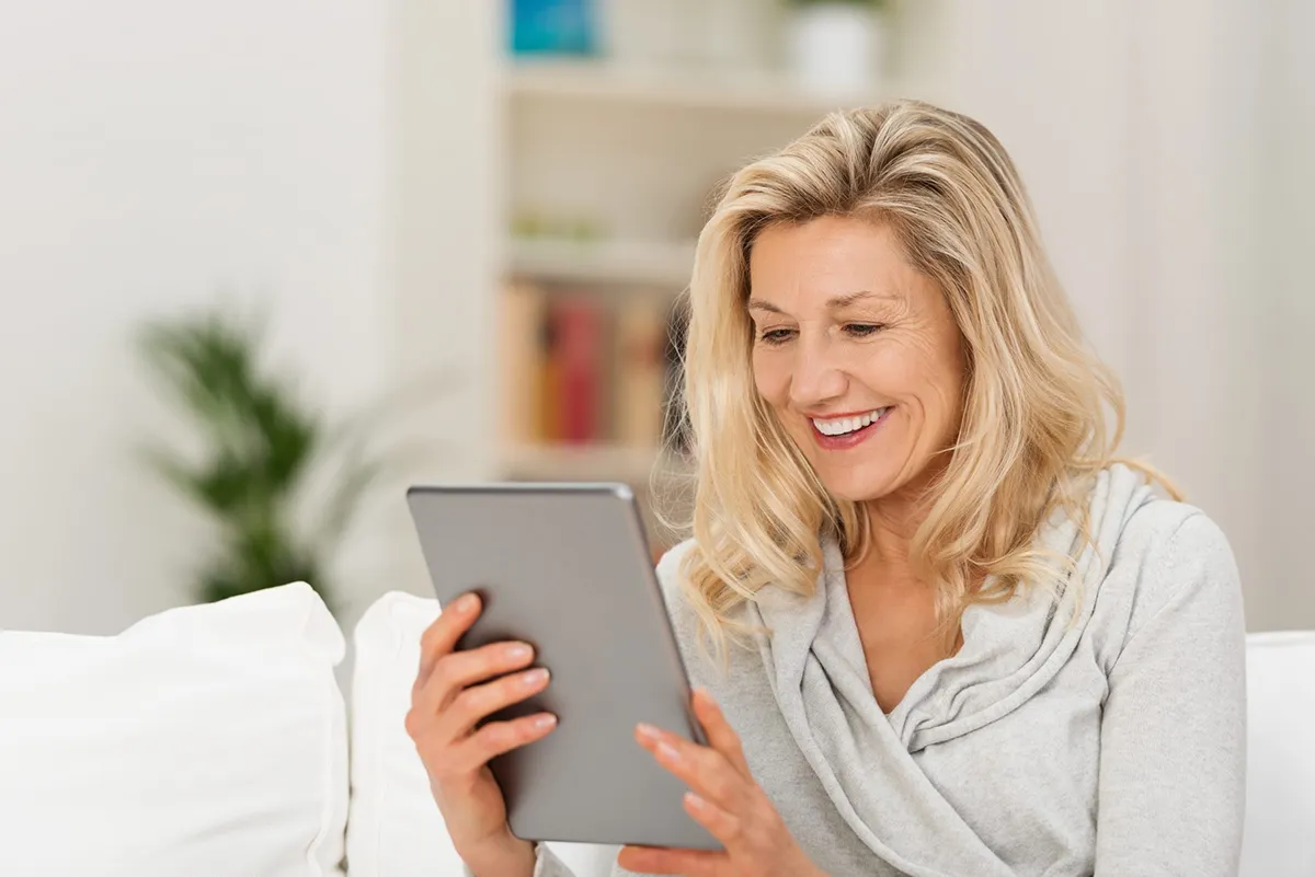 woman smiling looking at tablet